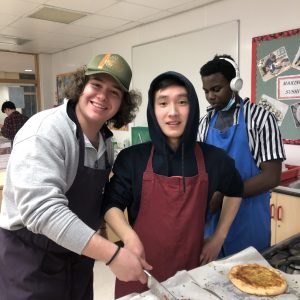 school children making pizzas