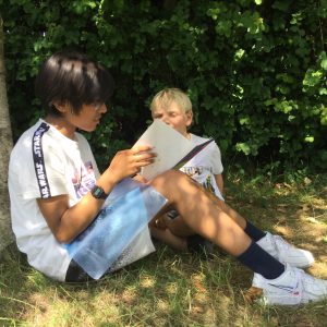 students reading outdoors