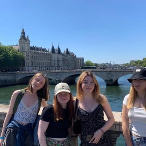 4 students smiling on a bridge in Paris