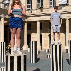 Students stood on different levels of black and white striped concrete pillars