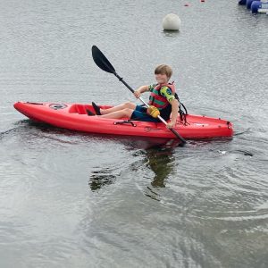 Student in canoe using oars
